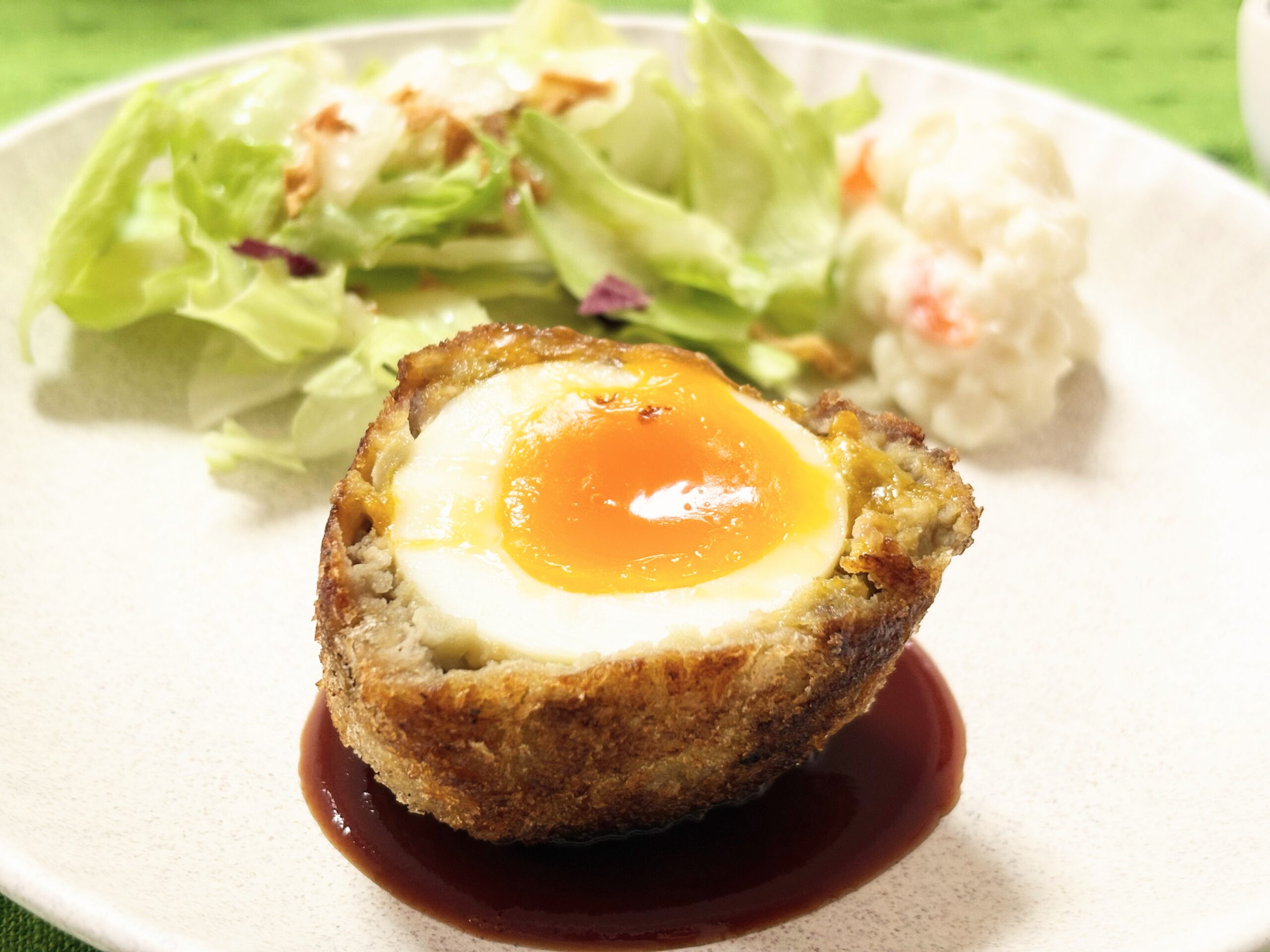 フライパンで簡単に作れる揚げないスコッチエッグ。ゆで卵を合いびき肉で包み、ジューシーに焼き上げた家庭料理。